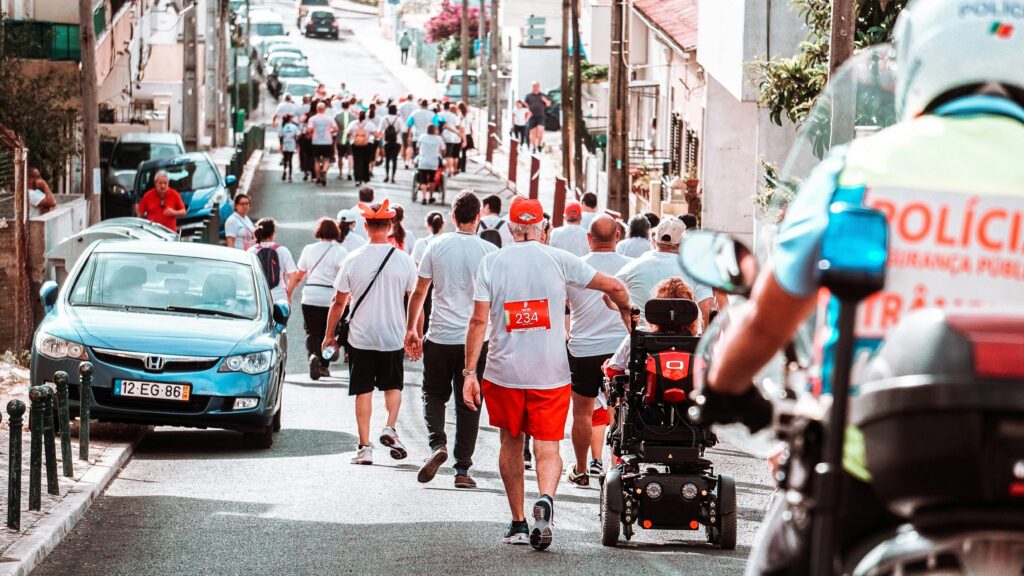 A diverse group of people participating in an urban footrace on a sunny day.