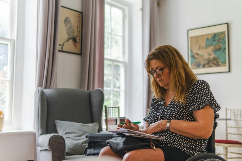 A woman sitting in a cozy living room writing notes, enhancing productivity.