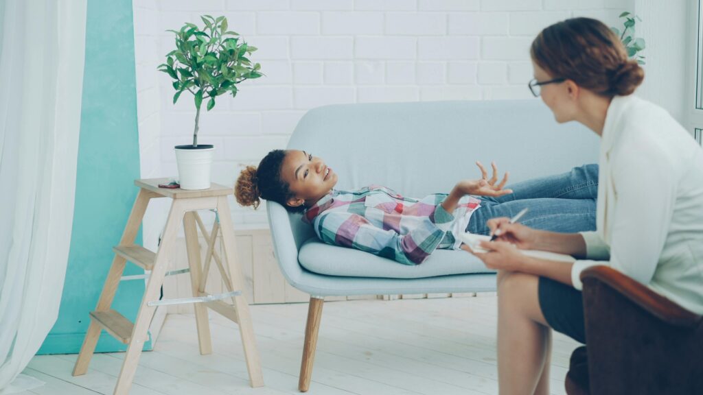 Cozy therapy office with client and therapist during a session.