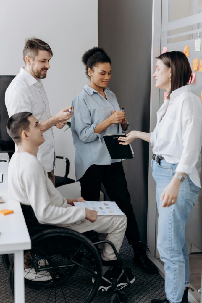 A diverse group of professionals collaborating in an office setting, fostering teamwork and inclusion.