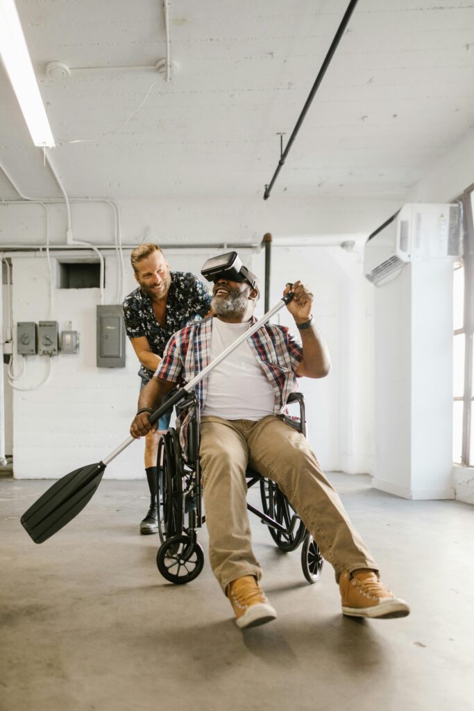 A man in a wheelchair enjoys virtual reality with an oar indoors.
