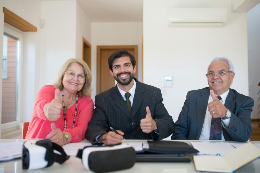 A diverse group in a meeting celebrating a successful agreement with thumbs up.